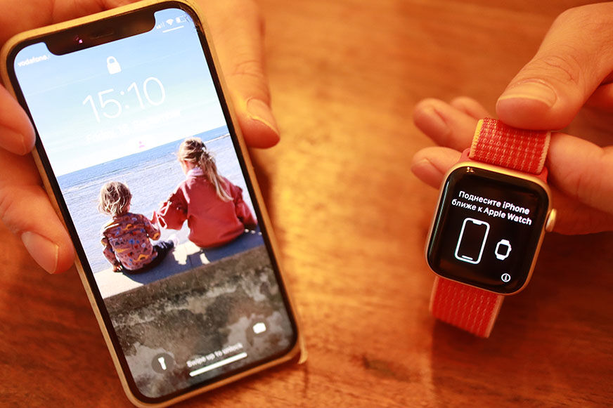 Man sieht die Apple Watch SE neben einem iPhone.
